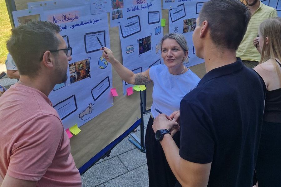 Teilnehmende eines Workshops zu den Sinus-Jugendmilieus diskutieren an einer Pinnwand